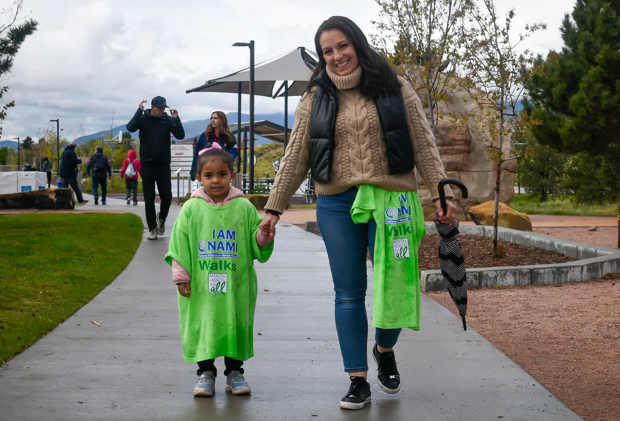 Adult and young child walking hand in hand at NAMIWalks