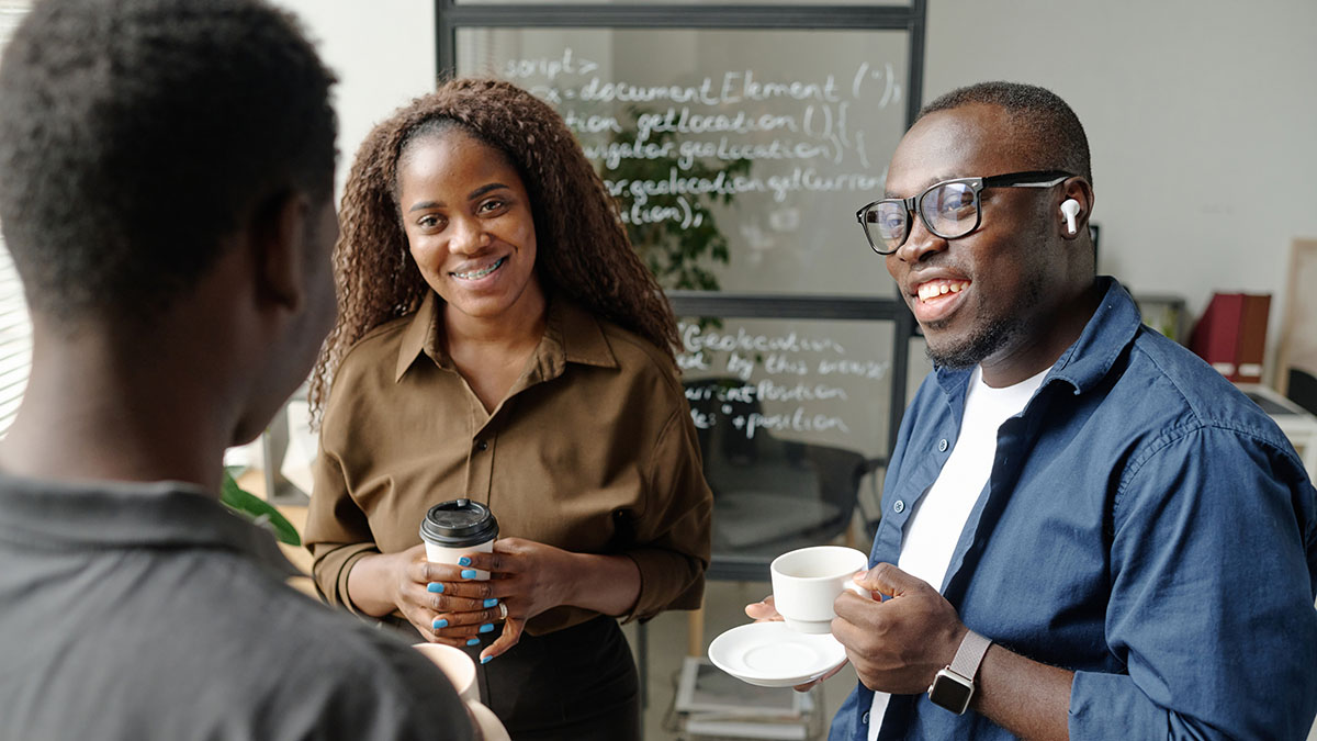 Small group of black friends having a conversation while drinking coffee