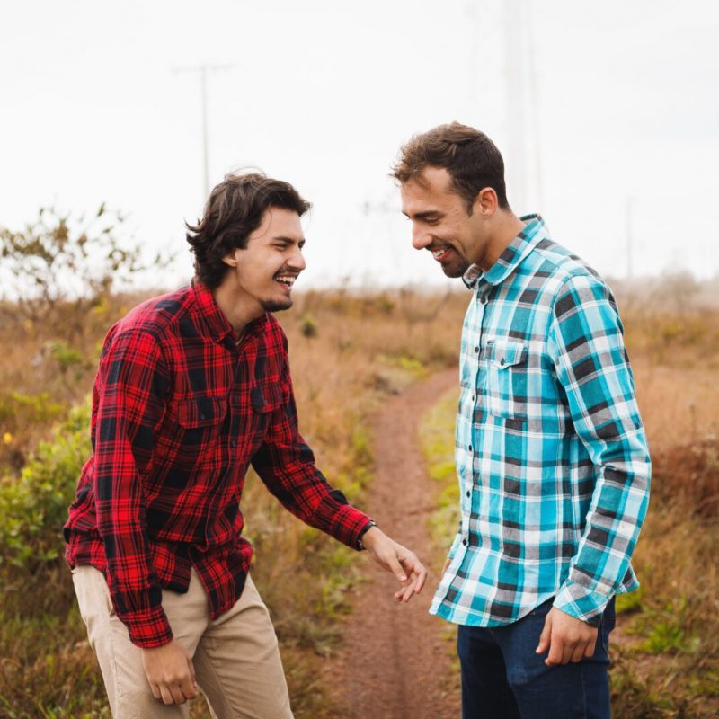 a couple of men standing next to each other on a dirt road