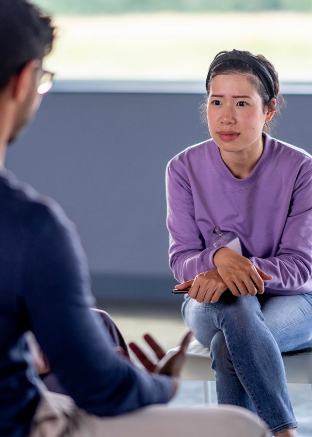 Young woman listening closely to a person sharing with a group