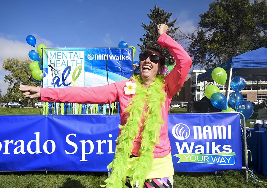 Woman laughing and dancing with a feather boa around her neck