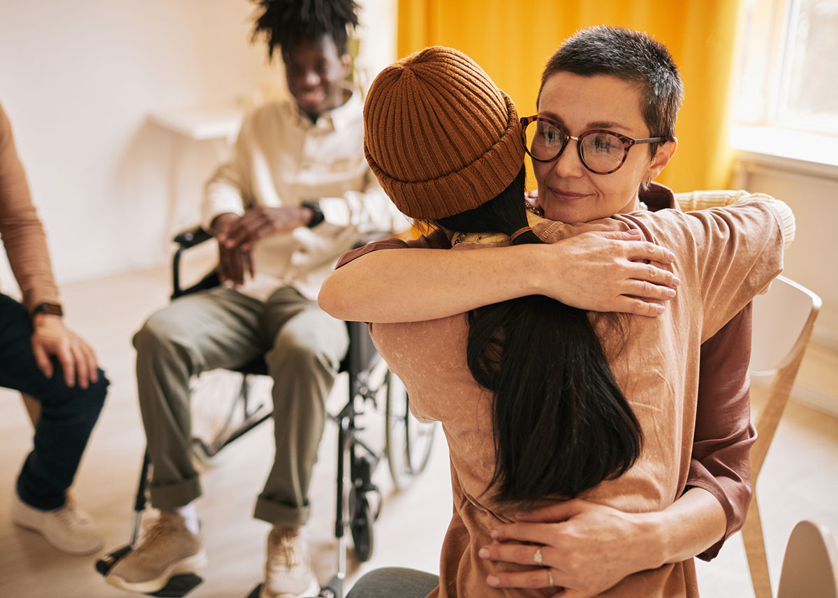 Two women hugging each other in a support group