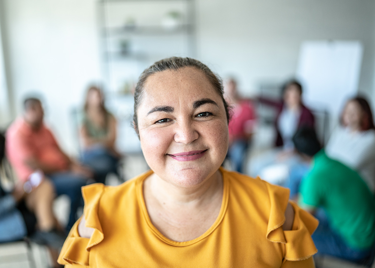 Woman smiling with out-of-focus group in the background