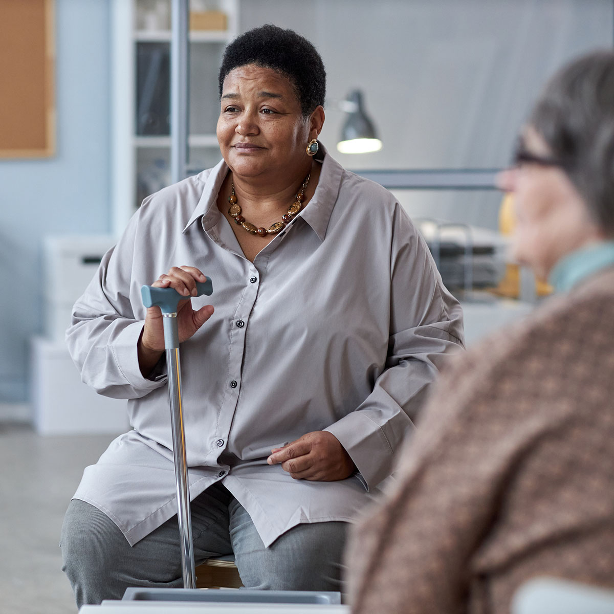 Woman with cane sitting in a support group