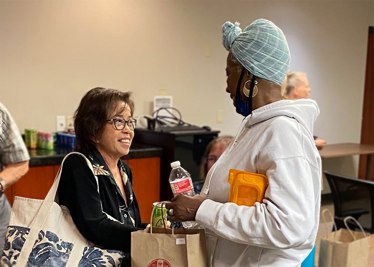 Two women talking while carrying snacks